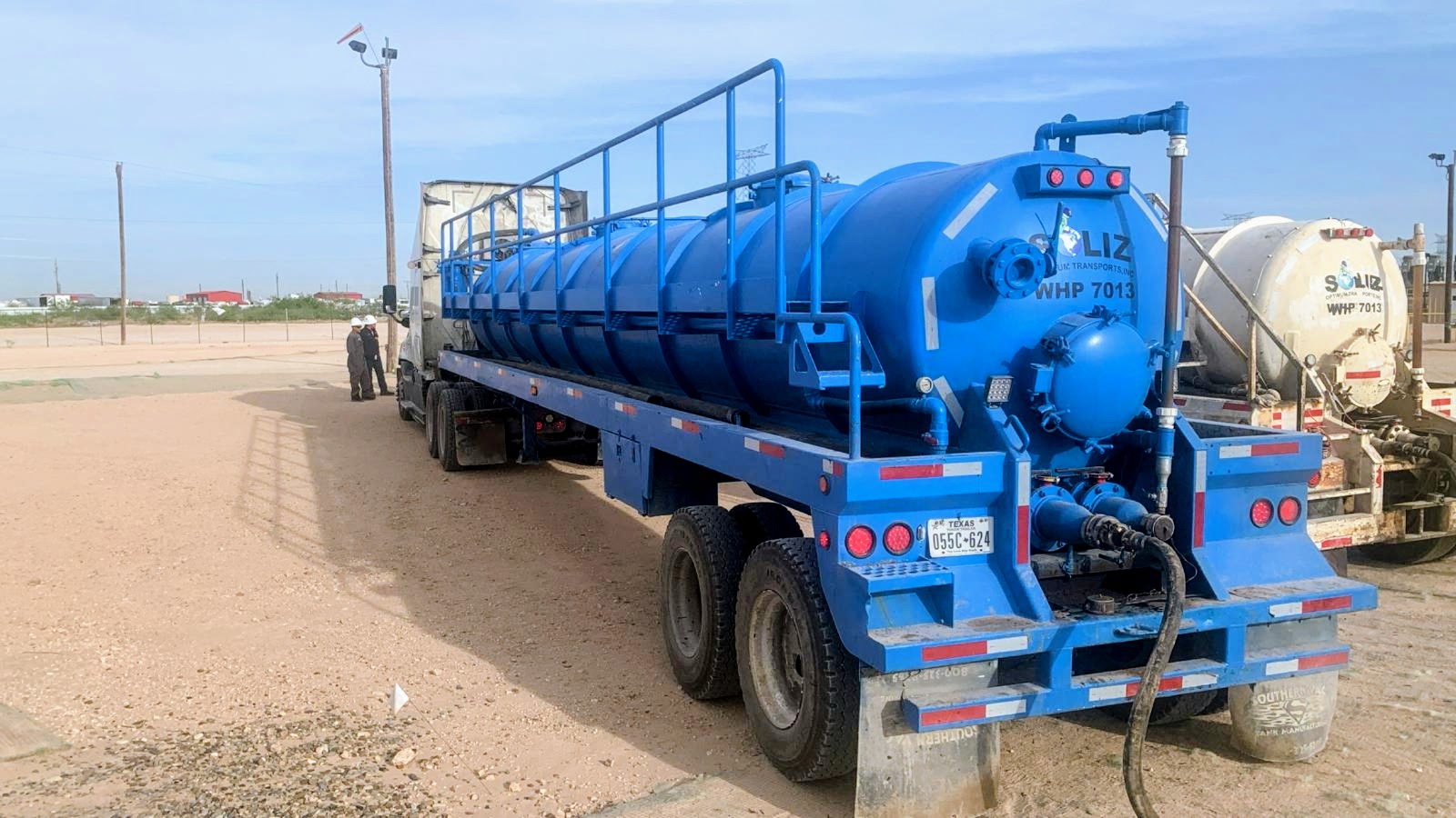 Blue Soliz Optimum Energy tanker trailer with crew nearby.